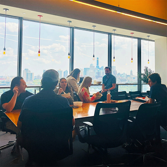 Team members eating lunch at a conference table in the office